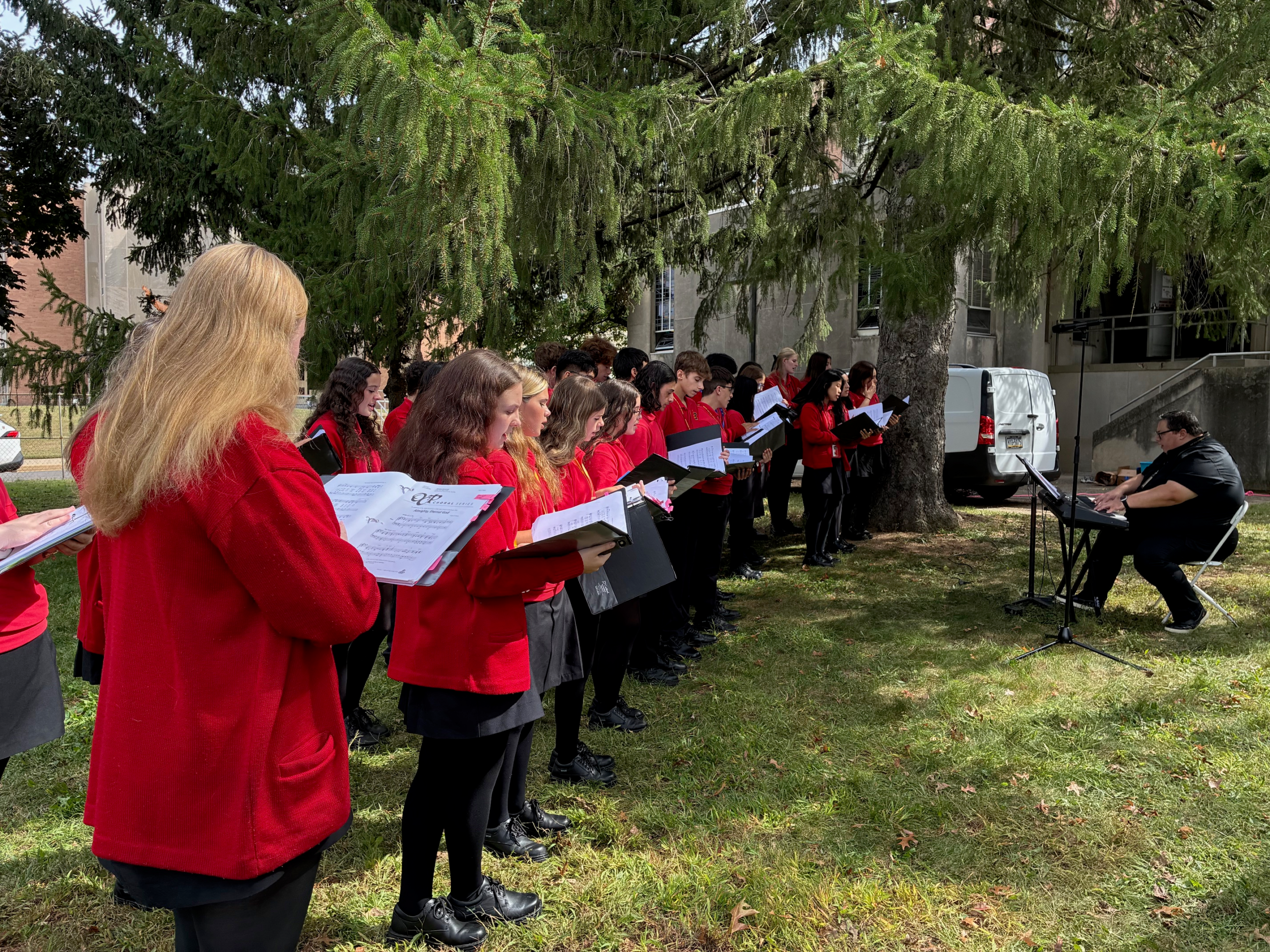 a choir wearing red jackets and singing