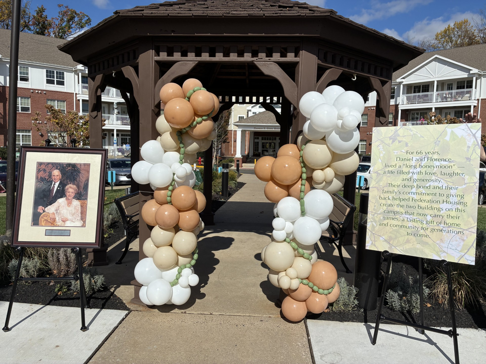 The gazebo in the garden has balloons and 2 plaques honoring the couple whose names grace the properties